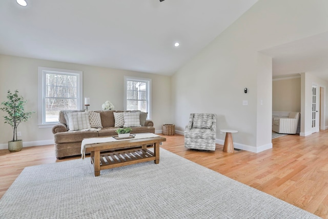 living room with recessed lighting, baseboards, lofted ceiling, and light wood-style floors