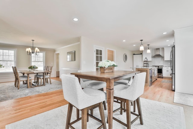 dining area featuring recessed lighting, crown molding, and light wood finished floors