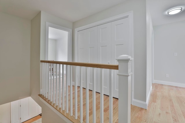 hall featuring baseboards and light wood-style floors