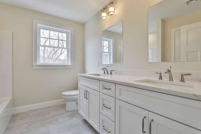 bathroom with a sink, visible vents, baseboards, and toilet