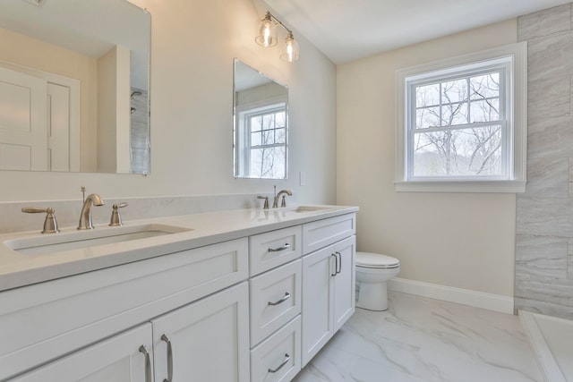 full bathroom featuring a sink, baseboards, marble finish floor, and double vanity