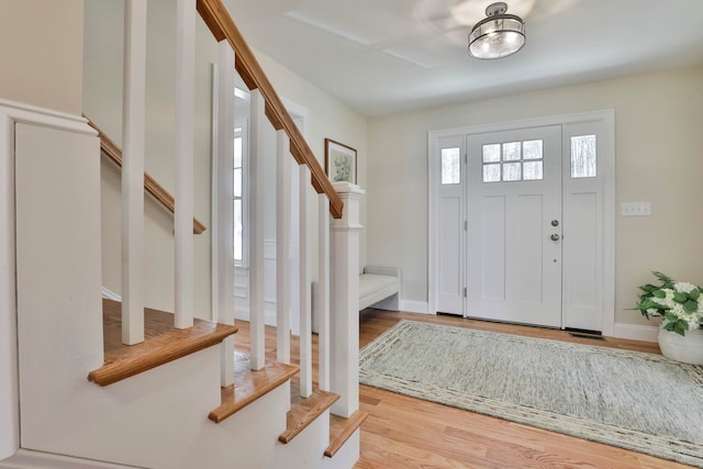 entryway featuring stairs, wood finished floors, and baseboards