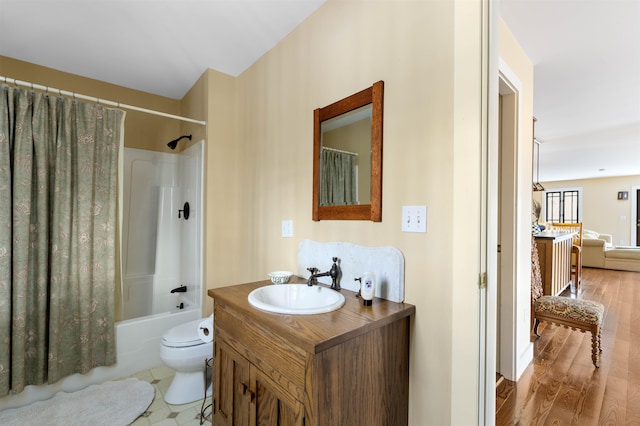 bathroom with toilet, vanity, shower / tub combo, and wood finished floors