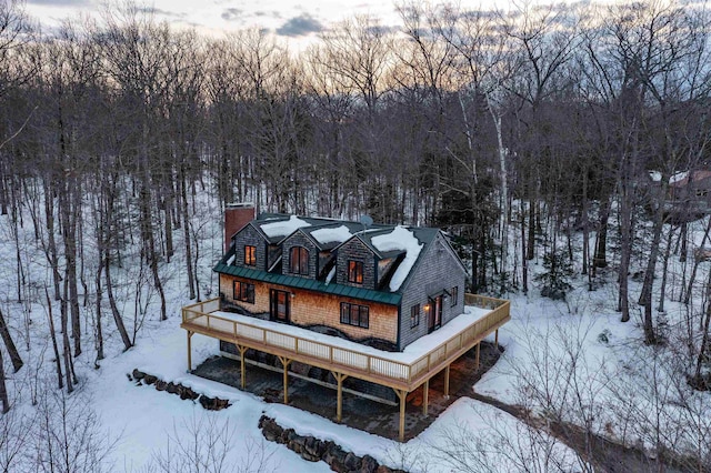 snowy aerial view featuring a forest view