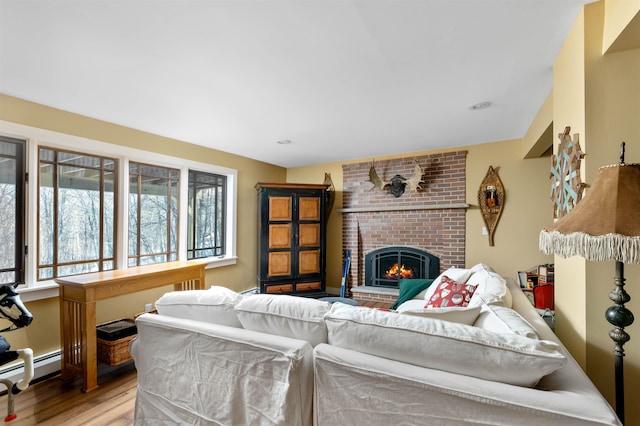 living room with light wood-type flooring and a brick fireplace