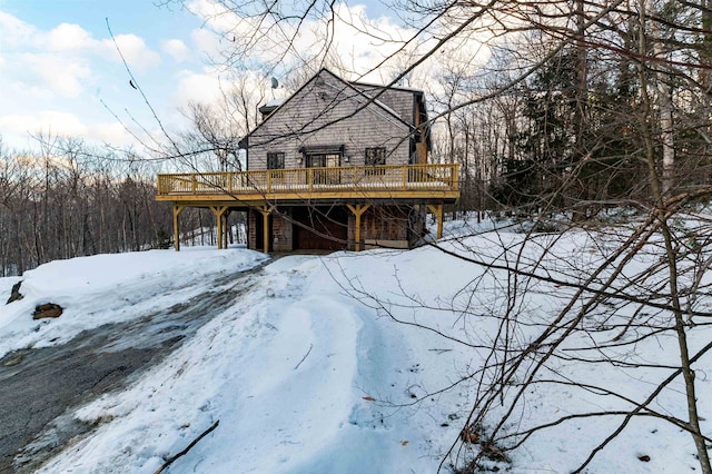 view of snowy exterior with a wooden deck