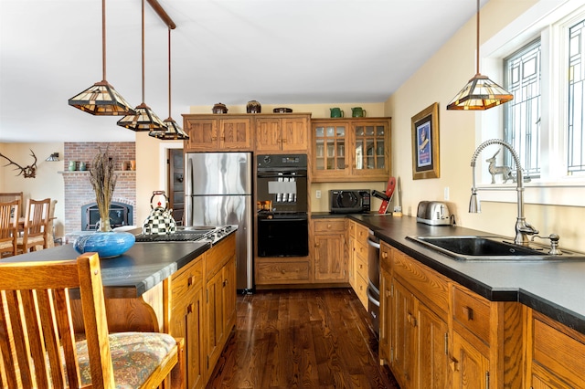 kitchen featuring a sink, brown cabinets, freestanding refrigerator, dobule oven black, and dark wood-style flooring