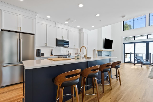 kitchen featuring visible vents, white cabinetry, appliances with stainless steel finishes, light wood finished floors, and light countertops