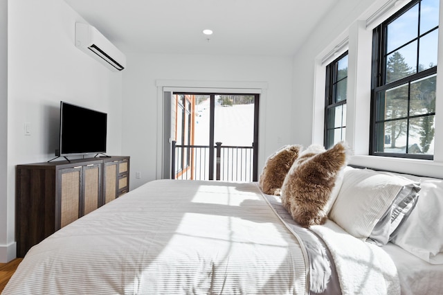 bedroom with a wall unit AC, access to outside, and multiple windows