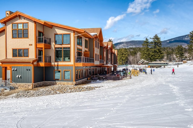 snow covered building featuring a mountain view