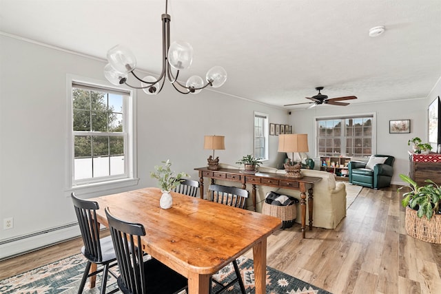 dining space with a wealth of natural light, ceiling fan with notable chandelier, and light wood-style floors