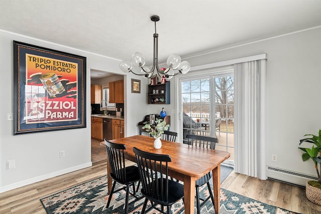 dining room featuring a baseboard radiator, baseboards, a chandelier, and light wood-style flooring