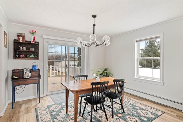 dining room with a baseboard heating unit, baseboards, ornamental molding, light wood-style flooring, and a notable chandelier