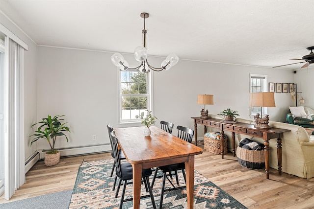 dining room featuring light wood-style flooring and ceiling fan with notable chandelier