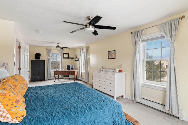 bedroom with a baseboard heating unit, light carpet, baseboards, and ceiling fan