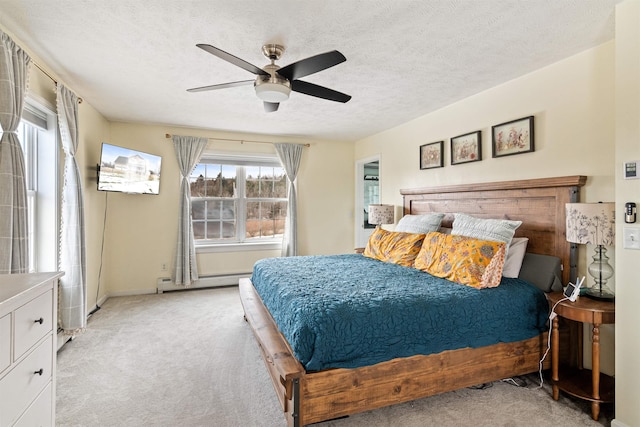 bedroom featuring light carpet, baseboard heating, ceiling fan, and a textured ceiling