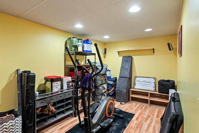 exercise area with recessed lighting, a paneled ceiling, and wood finished floors