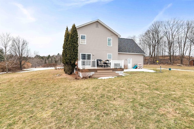 rear view of property featuring a deck and a lawn