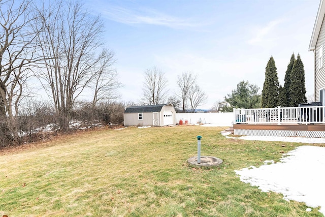 view of yard with a wooden deck, an outbuilding, and fence