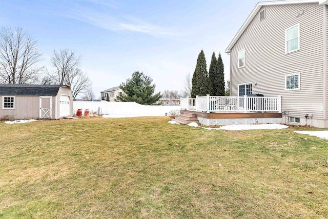 view of yard featuring fence, an outdoor structure, a storage unit, a garage, and a deck