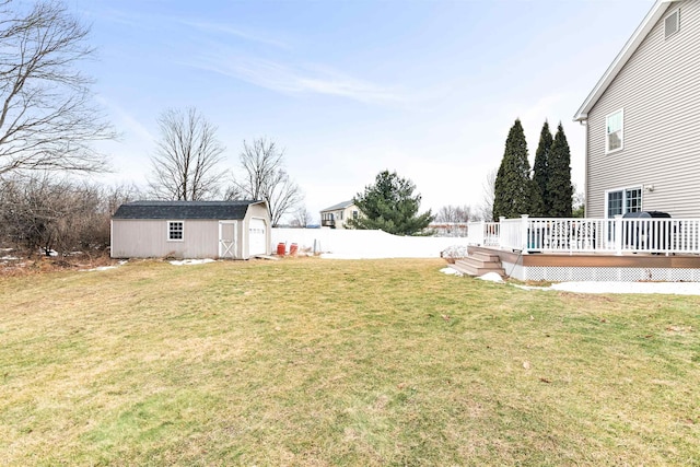 view of yard with an outbuilding, a storage unit, fence, and a wooden deck