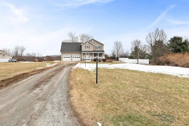 traditional-style home with a front yard, fence, driveway, an attached garage, and a shingled roof