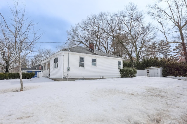 snow covered property featuring a chimney