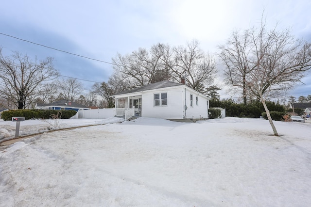 view of front of property with a chimney and fence