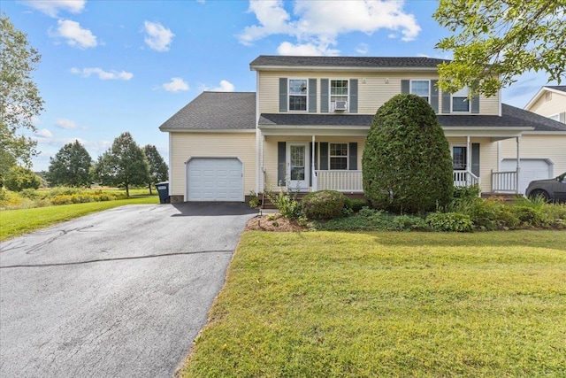 view of front of house with a garage, covered porch, driveway, and a front yard