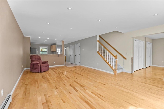 unfurnished room featuring baseboards, a baseboard radiator, recessed lighting, stairs, and light wood-type flooring