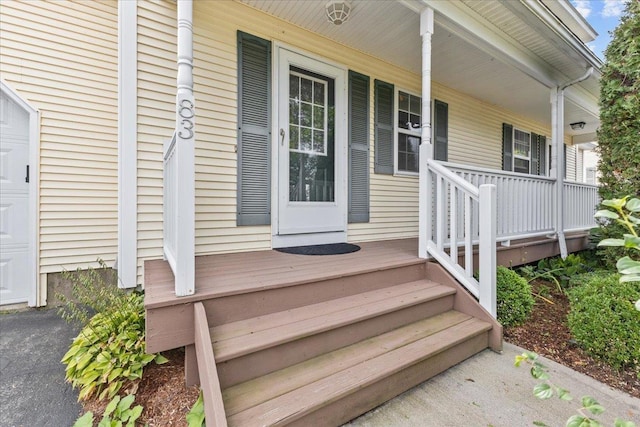 view of exterior entry featuring a garage and covered porch