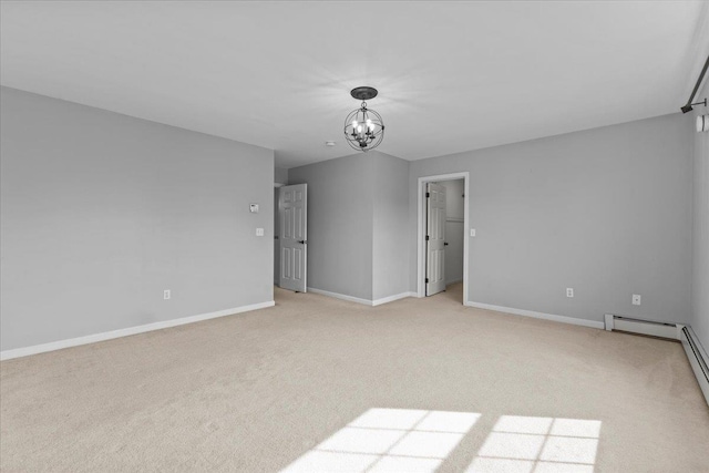 empty room with a notable chandelier, light colored carpet, a baseboard heating unit, and baseboards