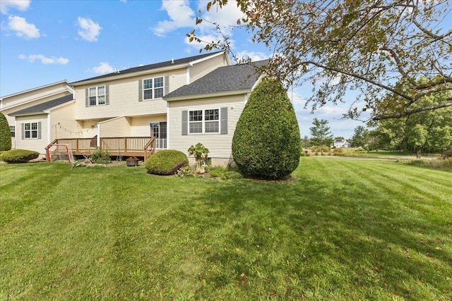 back of property with a lawn and a deck