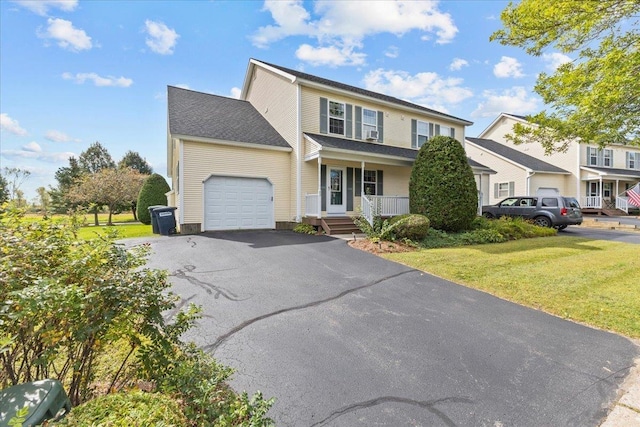 view of front of house featuring a front yard, a porch, a garage, and aphalt driveway