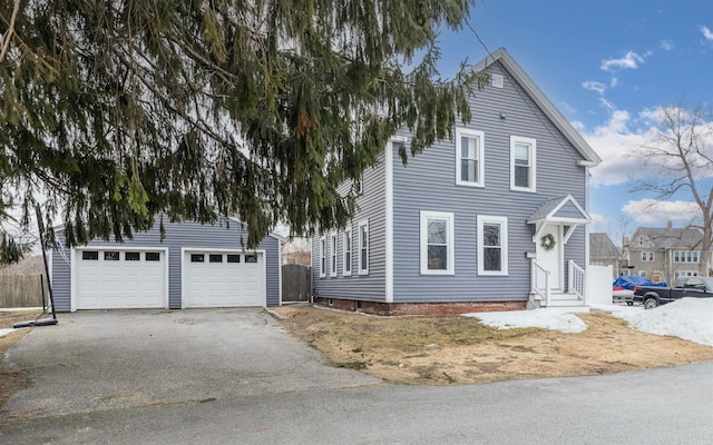 view of front of home with a garage, an outdoor structure, and driveway