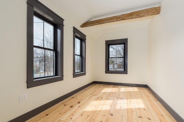 spare room with vaulted ceiling with beams, baseboards, and wood-type flooring