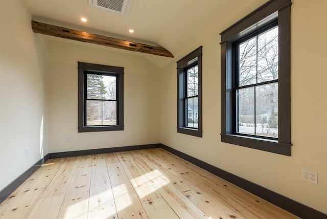 empty room with hardwood / wood-style floors, a healthy amount of sunlight, visible vents, and baseboards