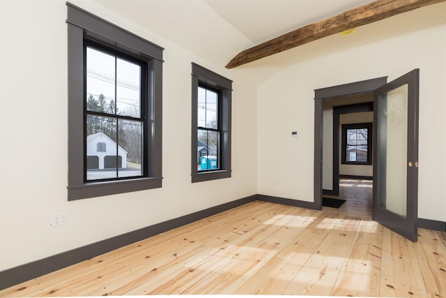 empty room with vaulted ceiling with beams, baseboards, and light wood finished floors