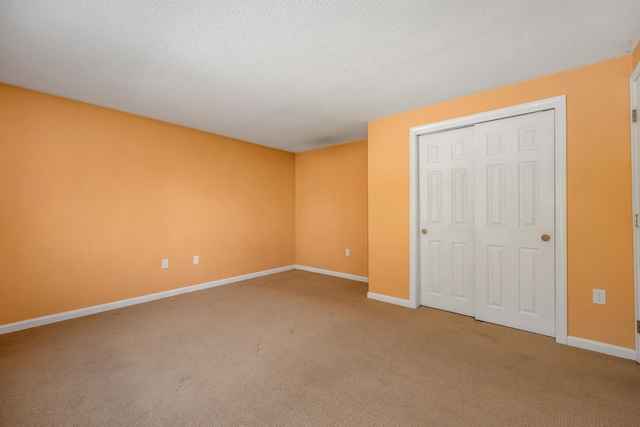 unfurnished bedroom with a closet, a textured ceiling, baseboards, and carpet floors