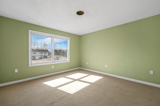 carpeted spare room featuring baseboards