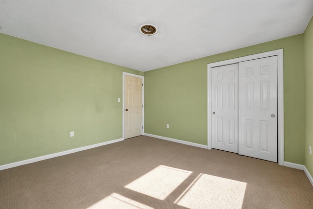 unfurnished bedroom with a closet, baseboards, and carpet