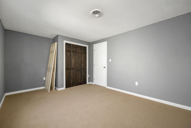 unfurnished bedroom with baseboards, visible vents, a closet, and carpet floors