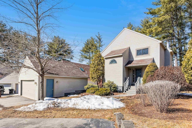 traditional home featuring an outbuilding, an attached garage, and driveway