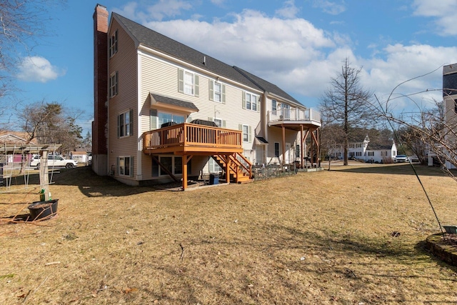 rear view of property with a wooden deck, a lawn, a chimney, and stairs