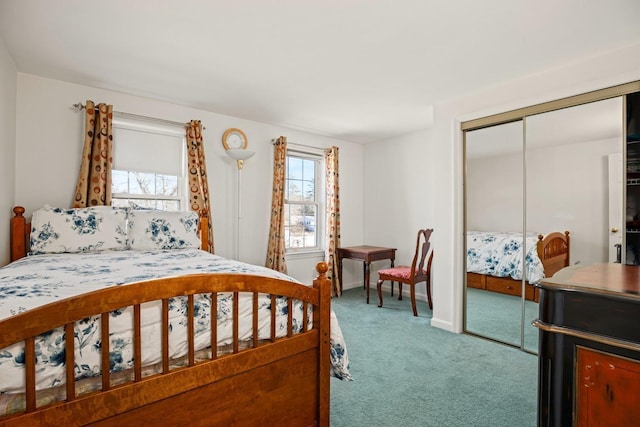 carpeted bedroom featuring a closet and baseboards