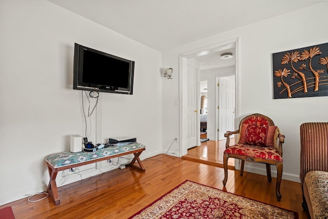 living area with baseboards and light wood finished floors