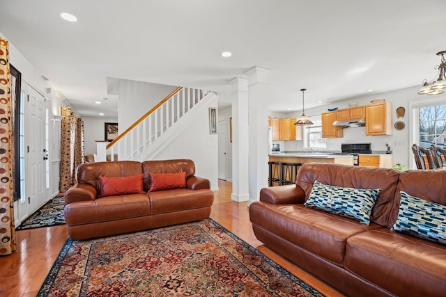 living room with stairway, baseboards, decorative columns, recessed lighting, and light wood-style floors