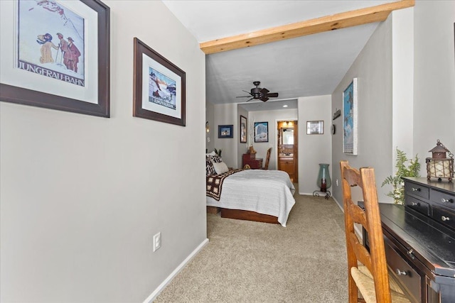 carpeted bedroom featuring beamed ceiling, a ceiling fan, and baseboards