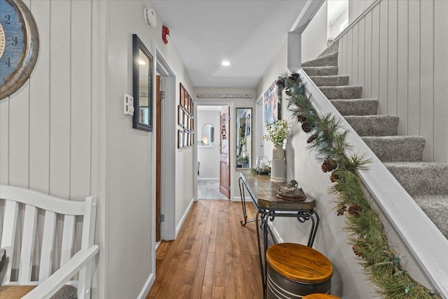 hallway featuring stairs, baseboards, and hardwood / wood-style flooring