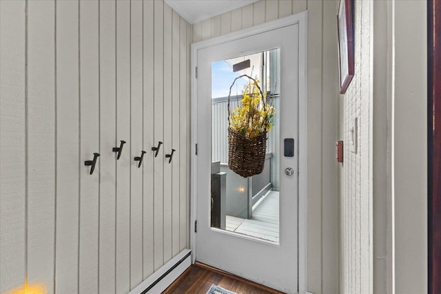 entryway with a baseboard heating unit, dark wood-style flooring, and wood walls